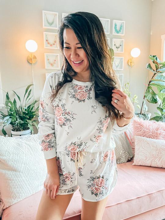 woman wearing floral pajamas in front of pink couch